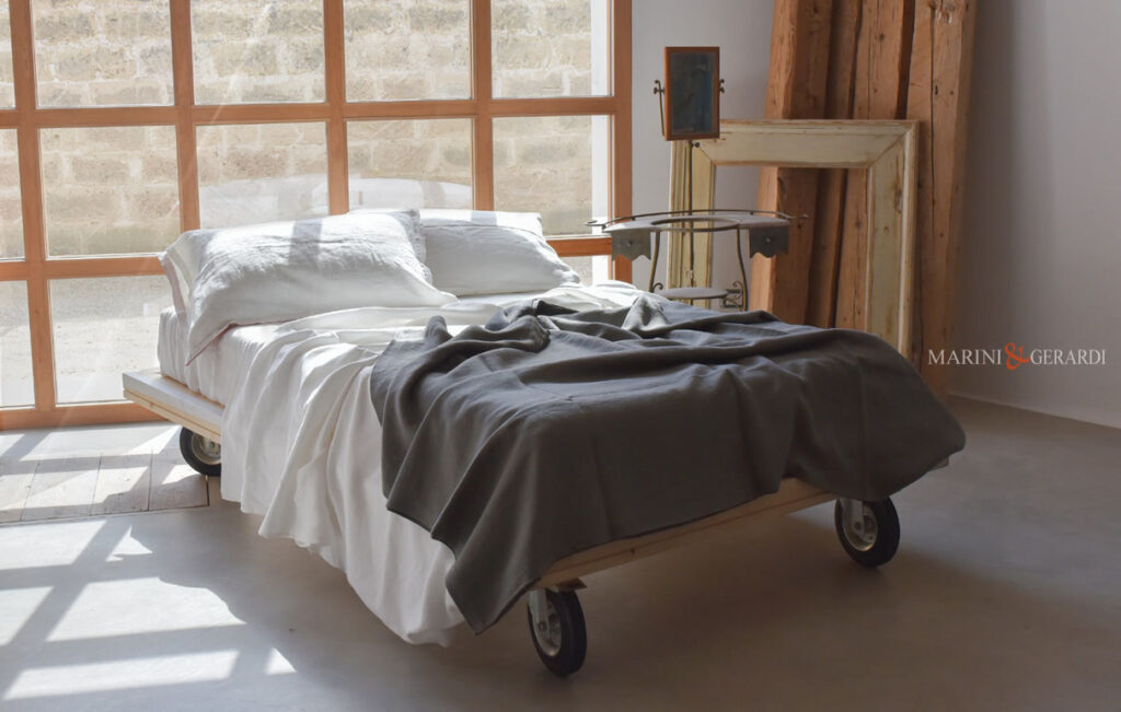Letti con ruote per camerette in legno massello e lenzuola in lino
